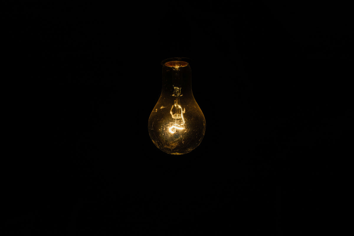 Bombilla incandescente encendida contra un fondo negro